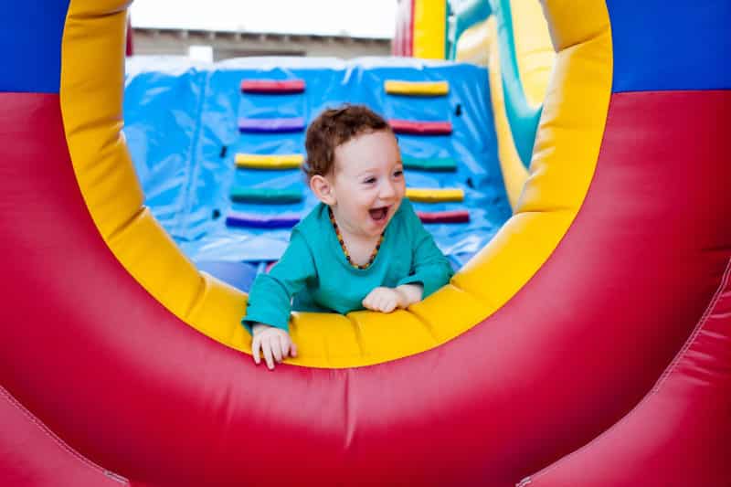 toddler peeking out on jumping castle